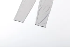 Detalle en primer plano de los puños de las piernas de un mono gris de malla