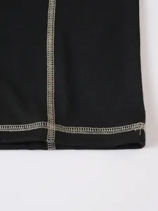 Détail du t-shirt Henley pour hommes avec des coutures contrastées sur un tissu noir souple.