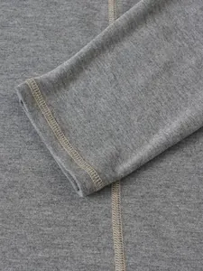 Gros plan du poignet d'un chemisier Henley gris avec des coutures plates durables.