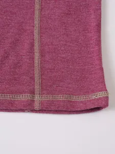 Gros plan montrant les coutures et le tissu de haute qualité d'un pull Henley rose chiné