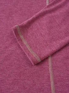 Gros plan sur les coutures contrastées et le tissu d'un t-shirt rose à manches longues
