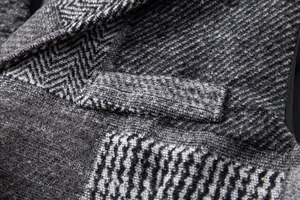 Détail macro du tissu en mélange de laine patchwork rétro sur une poche de gilet d'homme.