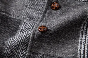 Gros plan sur le tissu gris à motifs vintage et les boutons de ce gilet pour homme