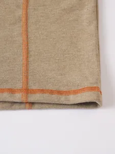 Détail macro de haute qualité de coutures plates oranges sur un tissu jersey chiné beige