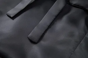 Gros plan macro montrant la texture tissée fine du tissu noir d'un gilet de costume pour homme