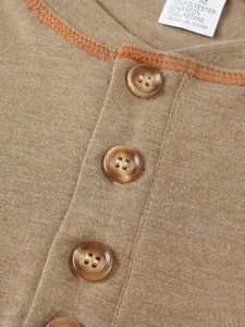 Détail d'un t-shirt Henley pour homme montrant les boutons et la couture contrastée.