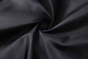 Gros plan sur la texture du tissu en satin noir lisse pour un gilet de costume homme