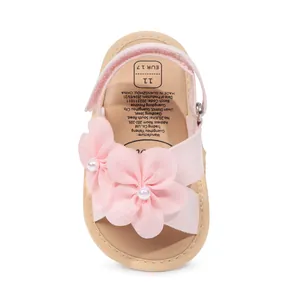 Dettaglio dei sandali principessa rosa per neonata con decorazioni floreali e perle