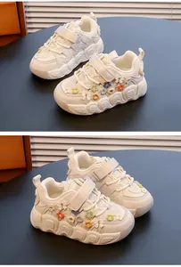 Detail of girls' cream sneakers featuring colorful 3D flower decorations and thick soles
