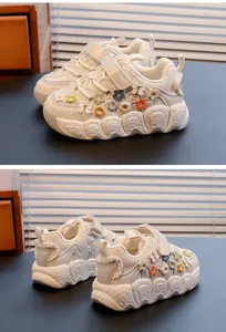Detailed view of white girls' sneakers with colorful embroidered flowers and soft soles.