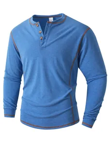 Gros plan sur un t-shirt Henley bleu avec coutures contrastées et boutons en bois.