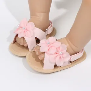 Visuale dei sandali rosa per neonata con eleganti decorazioni di fiori in tessuto