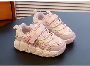 Detailed view of pink girls' sneakers featuring 3D floral accents and wavy soles