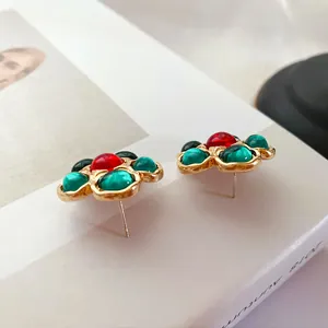 Gros plan élégant de boucles d'oreilles vintage en forme de fleur avec gemmes colorées