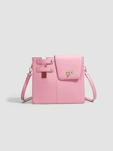 Detailed view of the pink crossbody bag featuring a unique strap and gold lock