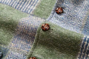 Gros plan sur le tissu patchwork rétro et les boutons texturés d'un gilet pour homme