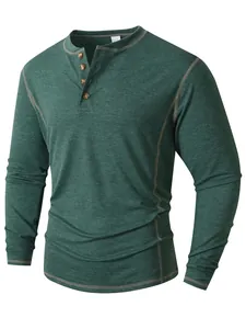 Détail d'un t-shirt Henley à manches longues vert foncé avec quatre boutons et surpiqûres.