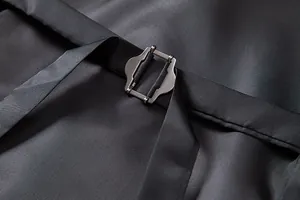 Gros plan de la boucle métallique réglable sur le gilet de costume vintage noir pour homme