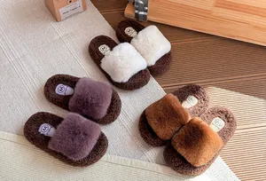 Vista dall'alto di comode pantofole in peluche per bambine in bianco, viola e marrone.