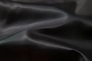 Gros plan détaillé sur la texture du tissu en satin noir lisse pour gilet d'homme