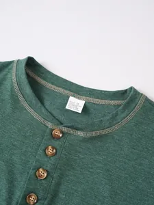 Détail du col d'un t-shirt Henley vert avec quatre boutons et texture du tissu.