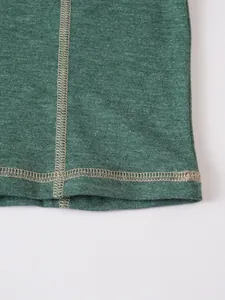 Détail en gros plan des coutures contrastées et du tricot chiné vert d'un haut décontracté