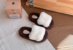 Vista dettagliata di ciabatte in peluche marroni e bianche per bambini con ecopelliccia