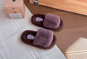 Scatto macro dettagliato di comode ciabatte in peluche viola e marrone per bambina su un tappeto