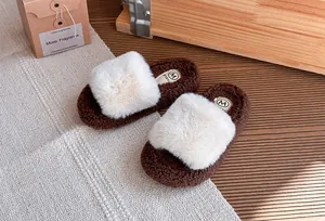 Dettaglio ravvicinato di pantofole in peluche marroni con soffice cinturino in eco-pelliccia