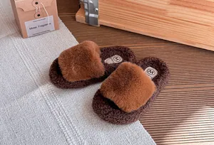 Vista dettagliata di pantofole in pelliccia sintetica marrone per bambine con texture