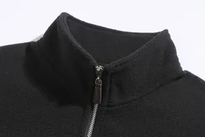 Detailopname van de opstaande kraag en metalen rits van het zwarte fleece sweatshirt