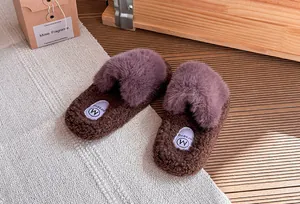 Primo piano di pantofole in ecopelliccia marrone e viola con suola spessa e consistenza soffice.