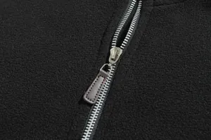 Gedetailleerde close-up van een rits op een zwarte heren sweatshirt van zachte fleece