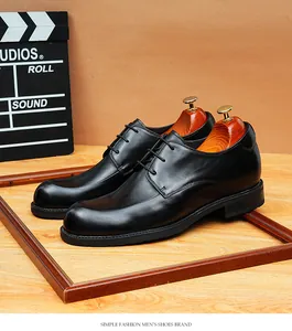 Gepolijste zwarte lederen Derby schoenen met verhoging op een rustieke houten basis.
