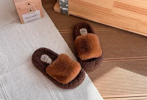 Dettaglio di pantofole platform in peluche marrone per bambine su un tappeto