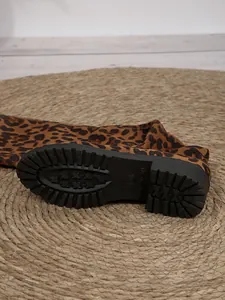 Dettaglio della suola in gomma nera di uno stivale sopra il ginocchio leopardato