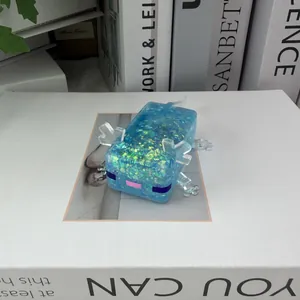 Détail d'un jouet anti-stress axolotl bleu à paillettes sur une surface de livre.