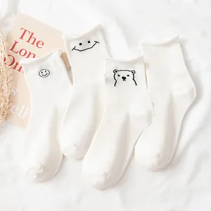 Kawaii set of four white cotton crew socks featuring embroidered bear and smiley face icons