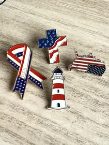 Gros plan de quatre pin's en émail sur le thème du drapeau américain, avec ruban USA