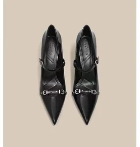 Vista superior de tacones negros de punta con elegante hebilla de metal y tachuelas