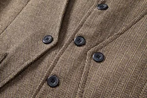 Nahaufnahme einer braunen Fischgräten-Retro-Herrenweste mit eleganten schwarzen Knöpfen