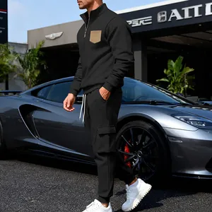 Detail showing men's black fleece sweatshirt and cargo pants set in a premium outdoor setting.