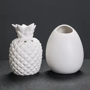 Moderne witte keramische ananas wierookbrander en eivormige houderset voor huis.