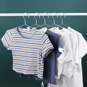Perchas de acero inoxidable resistentes colgadas en una barra blanca con varias camisas.