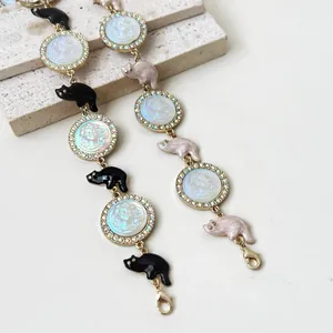 Detailed view of relief portrait pendants with rhinestones and colorful cat charms.