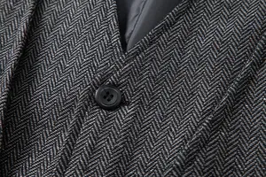 Makro-Detail von hochwertigem Vintage-Fischgräten-Tweed-Stoff und Knopf an Herrenweste