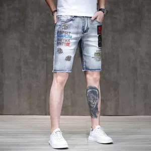 Detailed view of men's slim fit denim shorts featuring stylish bee and text embroidery