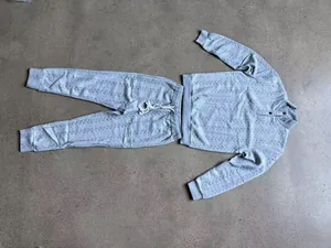 Vista detallada de un conjunto de sudadera Henley y pantalón gris con textura gruesa