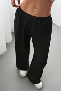 Close-up detail showing the fit of black wide-leg drawstring sweatpants on a model.