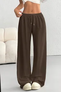 Detailed view of dark brown wide-leg pants with elastic drawstring waist and soft fabric